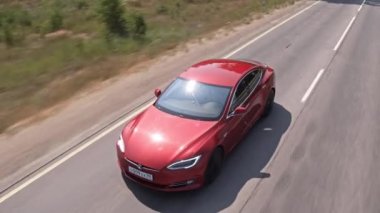 Tesla 'nın arabası yaz zamanı yolda gidiyor. Rusya Saint Petersburg 08.06.2021. Yüksek kalite 4k görüntü