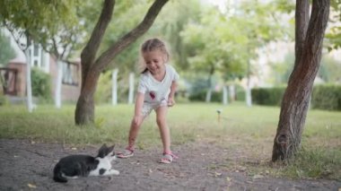 Küçük kız dışarıda kedilerle oynuyor Yaz günü