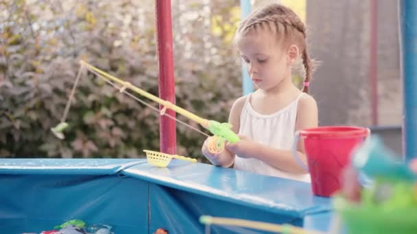 Kinderfischer fangen Plastikspielzeugfische am Sommertag im Freizeitpark am Pool — Stockvideo