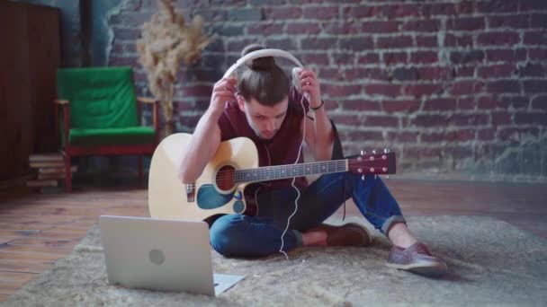 Caucasico giovane adulto che impara la chitarra online classe di musica con lontano computer insegnante dispositivo mobile — Video Stock