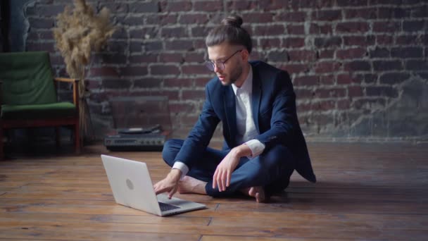 Freelancer finishing work closes laptop satisfied lotus position sitting floor living room — Stock Video