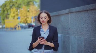 İş kadını akıllı telefon mesajları kullanıyor şirket ofisinde yürüyor cep telefonuna mesaj yazıyor.