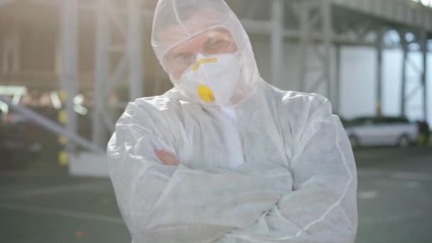 COVID-19 coronavirus doctor standing hospital parking dressed white protective overalls hazmat suit. — Stock Video