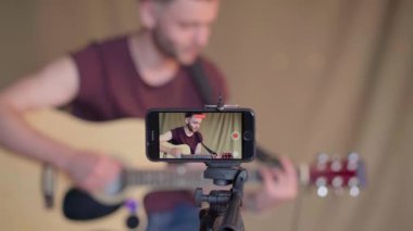Öğrenciler için gitar dersleri kaydeden bir adam. Online gitar kursları. Uzaklık öğrenme kavramı Aygıt ekranına odaklan