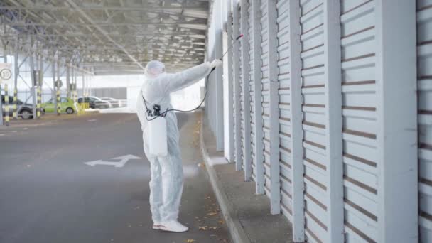 Arbeiter in Schutzanzügen desinfizieren öffentliche Flächen — Stockvideo