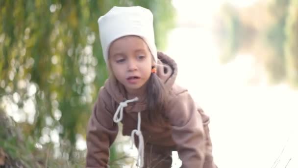 Klein gelukkig meisje buiten. Gelukkig leuk vrolijk meisje het hebben van plezier in park herfst seizoen — Stockvideo