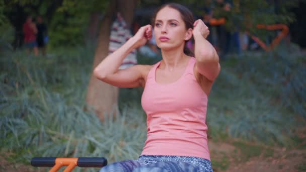 Athletic kobieta robi ćwiczenia brzucha na ławce ćwiczenia maszyna outdoor siłownia w parku piękny silny profesjonalny atletyczny kobieta trening na zewnątrz — Wideo stockowe