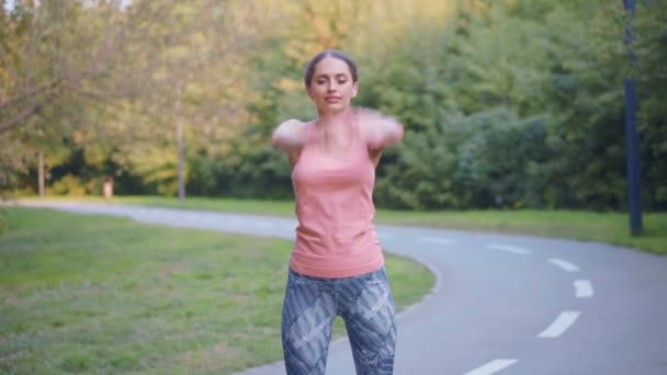 Woman runner stretching arms before running summer park — Stock Video