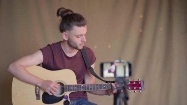 Öğrenciler için gitar dersleri kaydeden bir adam. Online gitar kursları. Uzaklık öğrenme kavramı