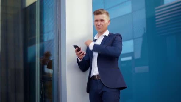 ビジネス、ビジネスマンは、スマートフォンの屋外オフィスビルの背景を使用 — ストック動画