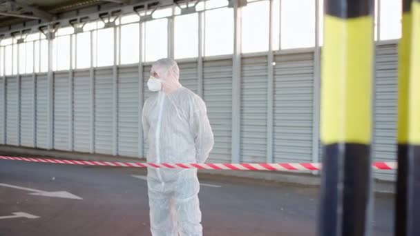 Hombre Epidemiólogo mostrando señal de stop de pie área restringida advertencia cinta blanca roja Coronavirus pandemia medidas de cuarentena — Vídeo de stock