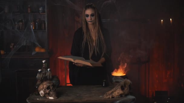 Halloween, heks gebruiken magische boek en ketel bereiden gif of liefdesdrank — Stockvideo