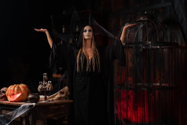 Απόκριες Μάγισσα Ντυμένη Μαύρη Κουκούλα Dreadlocks Στέκεται Σκοτεινό Δωμάτιο Μπουντρούμι — Φωτογραφία Αρχείου
