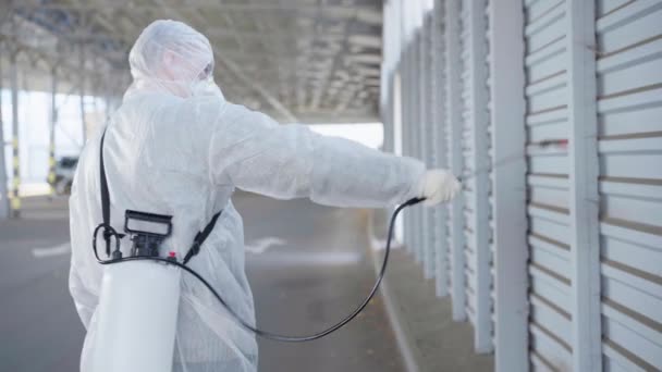 Arbeiter in Schutzanzügen desinfizieren öffentliche Flächen — Stockvideo