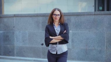 İş kadını portresi gözlüklü beyaz kadın iş adamı açık hava ceketi giyiyor gözlüğünü çıkarıyor ve gülümsüyor.