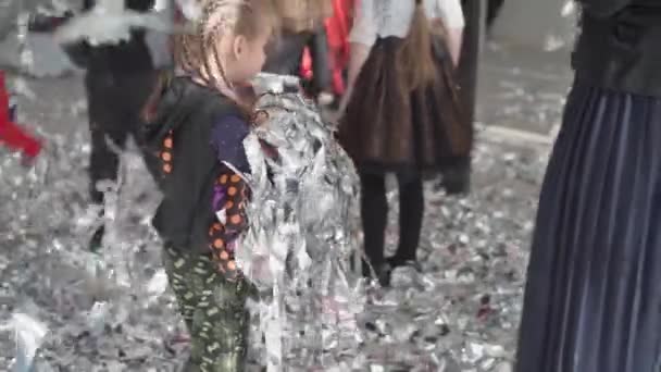 Liten flicka som har kul på sin födelsedag samlar blanka konfetti från golvet kastar upp positiva känslor kul — Stockvideo