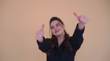 Siyah ceketli, mutlu, genç bir iş kadını. İki eline de iyi niyet göstermiş. Sonra da özel bir jest yapmış.