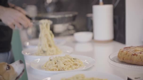 Pastas de Carbonara preparándose en sartén. Hombre mano de cerca pone en platos espaguetis con leche de camarones y crema — Vídeos de Stock