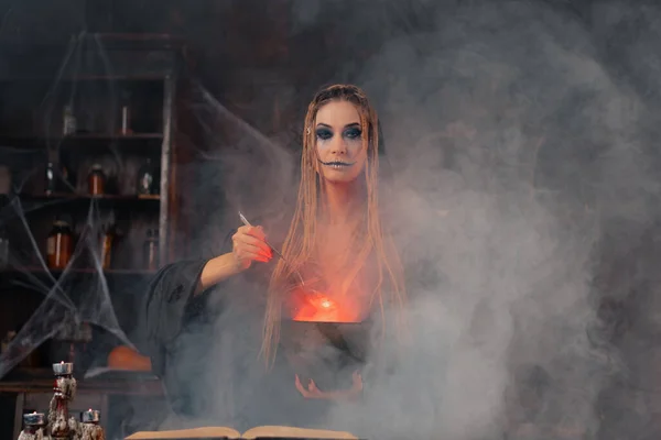 ハロウィーン 魔女は魔法の本を使用し 釜は毒や愛のポーションを準備します 煙と暗い部屋で黒魔法のオカルト女性ウィザード クモの巣 ネクロマンサー料理魔法のポーションで大きなスプーン — ストック写真