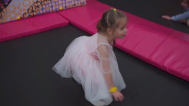 Trambolinde zıplayan bir çocuk. Kafkasyalı küçük kız, eğlence merkezinde trambolin oynayarak eğleniyor. 