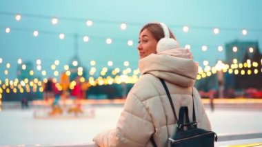 Kış zamanı. Noel tatili akşamı, buz pateni pistinin dışında dikilen kadın arkasına bakıp gülümsedi. Noel aydınlatması ve dekorasyon geçmişi. Kış tatili