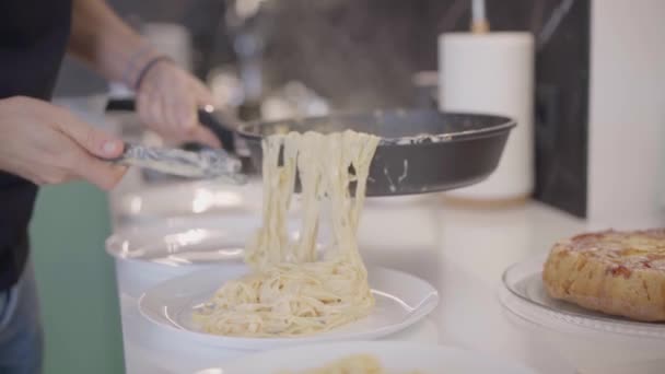 Carbonara pasta förbereder på pan. Man hand närbild sätter på tallrikar spaghetti med räkor mjölk och grädde — Stockvideo