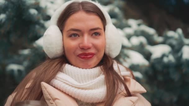 Närbild porträtt ung kvinna med päls hörselkåpor vinterdag utomhus — Stockvideo
