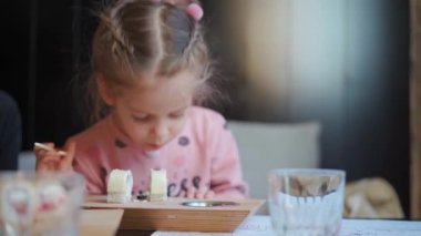 Çocuk restoranda saşimi yiyor. Annesiyle birlikte suşi ve sashimi yiyen küçük bir kızı evin içinde vur. Beyaz kadın çocuk Japon mutfağını tadıyor. 