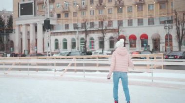 Kış zamanı. Noel tatili, örgü şapkalı bir kadın Central City Meydanı 'nda buz pateni pisti açık. Kış mevsimi. Beyaz, yetişkin, amatör buz patencisi kadın.
