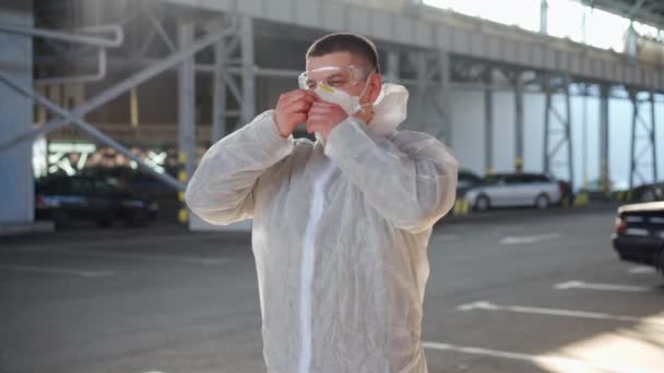 COVID-19 coronavirus γιατρός στέκεται νοσοκομείο στάθμευσης ντυμένοι λευκό προστατευτική στολή στολή Hazmat. — Αρχείο Βίντεο