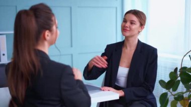 İş görüşmesi, iş, kariyer ve yerleştirme konsepti. Genç sarışın kadın gülümsüyor ve özgeçmişini tutuyor, adayın önünde otururken.