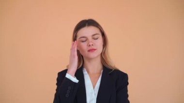 Şakaklarında acı çeken siyah ceketli Amerikalı kadın stresten muzdarip ya da pembe arka planda acı içinde kıvranan baş ağrısı çekiyor. Tıbbi konsept