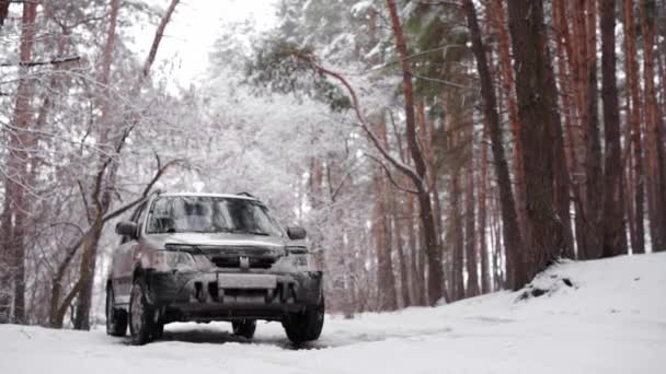 Winter rijden. Off-road rijden op winterbos besneeuwde weg. Een SUV auto staat land weg in de winter bos met sneeuw in slow motion — Stockvideo