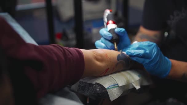 Hombre haciendo tatuaje en la mano femenina. Tatuaje artista haciendo tatuaje con máquina de equipo profesional de tatuaje — Vídeos de Stock