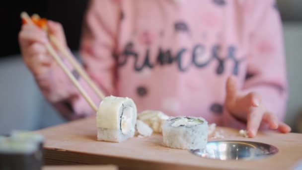 Dziecko je sashimi w restauracji. Dziewczynka w średnim wieku je sushi i sashimi w domu. kaukaska kobieta dziecko degustacja japońska kuchnia — Wideo stockowe