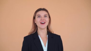 Kazanan genç iş kadını siyah ceketle gülüyor ve dans ediyor. 