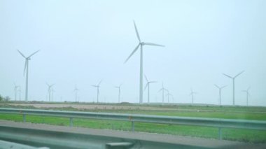 Büyük rüzgâr türbinleri ve tarla mavisi rüzgar parkları.