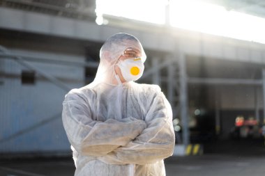 COVID-19 Coronavirus doktoru hastane otoparkında beyaz koruyucu tulum giymişti. Bulaşıcı hastalıklar, salgın hastalık. Erkek sağlık çalışanı orta boy çekim