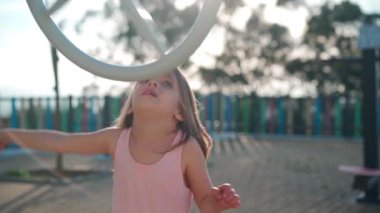 Çocuk sıcak yaz gününde oyun parkında oynuyor. Küçük kız eğleniyor. Mutlu çocukluk. 