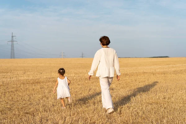 Malá Dívka Svou Matkou Oblečené Bílé Oblečení Chůze Pšenice Pole — Stock fotografie