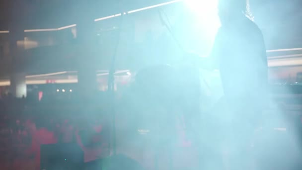 Man spelar etniska trummor stående på scenen i rök och spotlights — Stockvideo