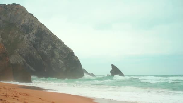 Ocean dzika plaża burzowa pogoda. Piaszczysta plaża Praia da Adraga z malowniczym krajobrazem, Sintra Cascais, Portugalia — Wideo stockowe