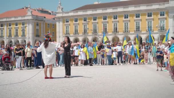 Portugalia, Lizbona, kwiecień 2022 r.: Demonstracja na Placu Handlowym na rzecz Ukrainy i przeciwko rosyjskiej agresji. Protestujący przeciwko wojnie rosyjskiej Wielu ludzi z ukraińskimi flagami. — Wideo stockowe
