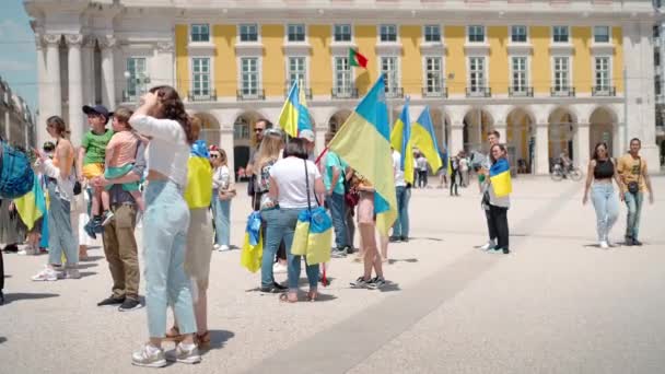 Portugal, Lisbon April 2022: The demonstration on Commerce Square in support of Ukraine and against the Russian aggression. Protesters against Russias war Many people with Ukrainian flags. — Stock video