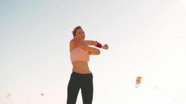 Esnek beyaz kız yoğun bir koşudan sonra kolunu esnetiyor. Atletik bayan orta yaş koşuya çıkmadan önce ısınıyor..