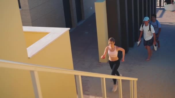 女运动员跑上楼去训练高强度的有氧运动在城市背景下跑步的女运动员 — 图库视频影像
