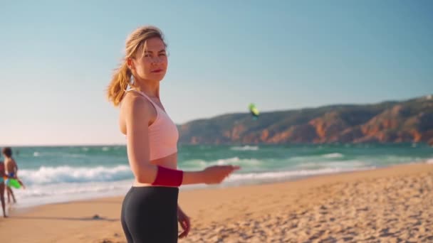 Slow motion ung vuxen passform kvinna stående havet stranden vänder sig om och kallar dig gest. Följ mig. Drake ombordstigning hav och berg på bakgrund — Stockvideo