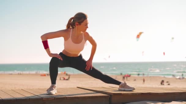 Slow motion sköt unga kvinnliga idrottare som tränar underkroppen motion. Hon gör framåt flyttar lunge mot fantastiska hav bergslandskap. — Stockvideo