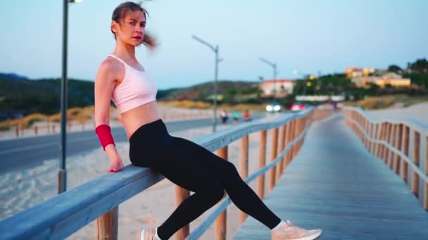 Retrato de mujer atlética al aire libre. Mujer caucásica mujer deportiva de pie en la naturaleza océano playa — Vídeos de Stock