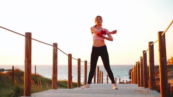 Flexibel kaukasisk tjej sträcker ut armen efter intensiv löpträning. Atletisk kvinnlig medelålder värmer upp innan jogging träning utomhus. — Stockvideo